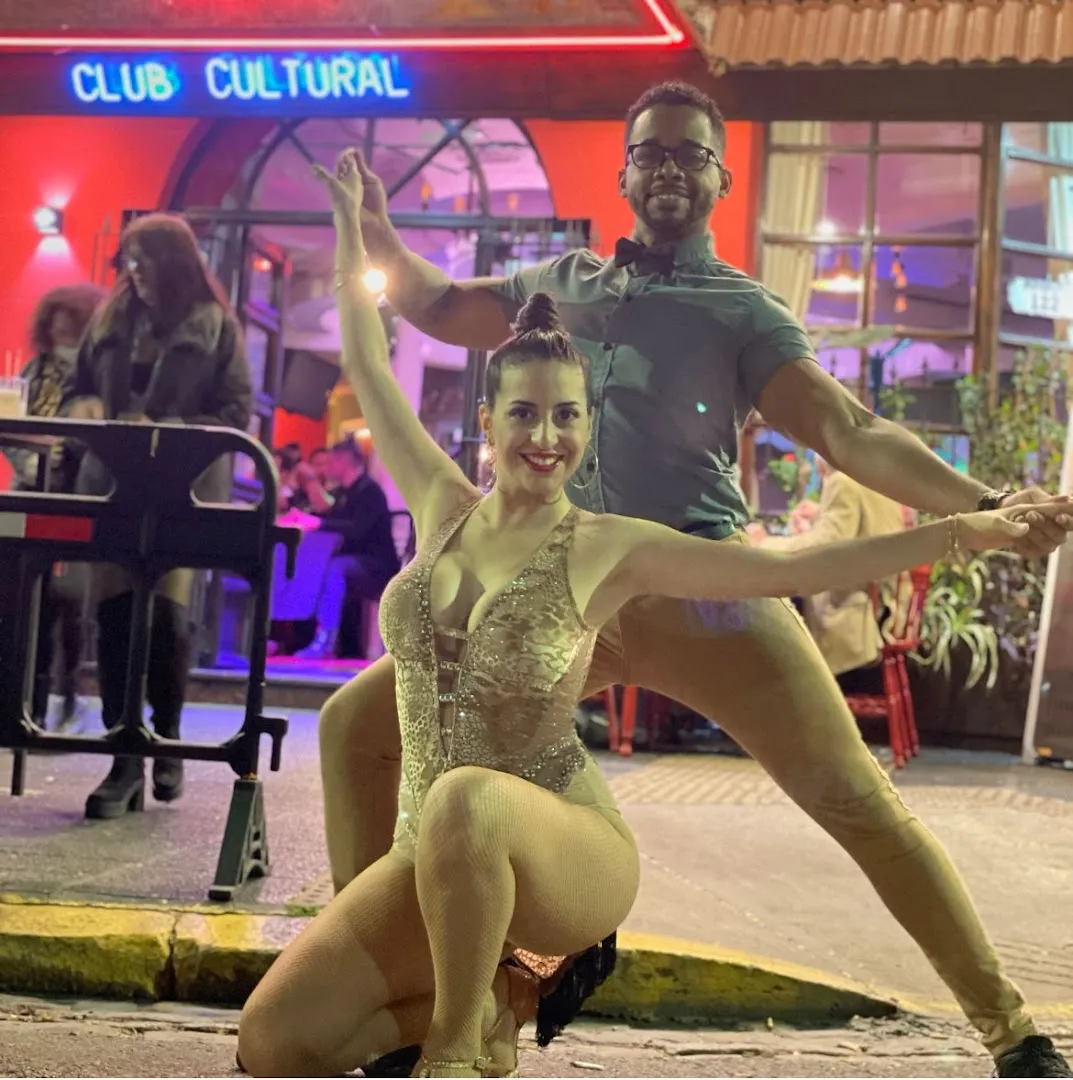 Bailarines en la puerta, bajo el cartel de Club Cultural