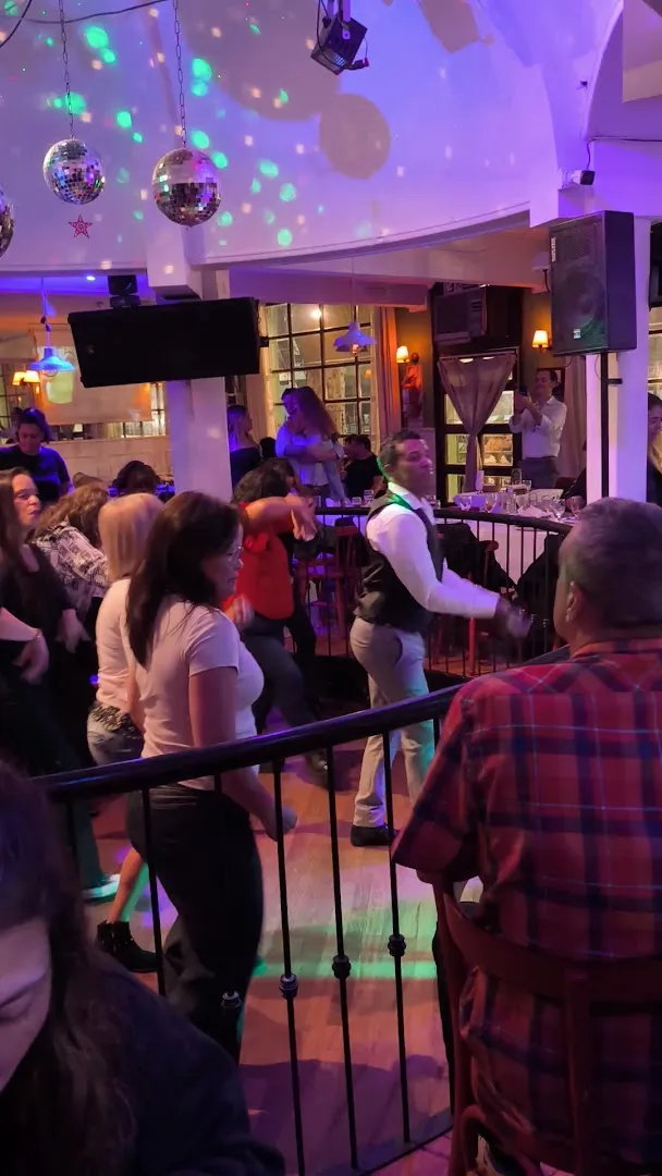 Gente bailando salsa en la pista, bajo las bolas de espejos